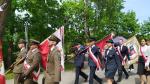 Park Miejski w Kielcach. Widok na trzech funkcjonariuszy służby Celno-Skarbowej, którzy maszerują w Poczcie Sztandarowym  Izby Administracji Skarbowej w Kielcach.